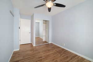 Unfurnished bedroom with a closet, ceiling fan, and dark hardwood / wood-style floors