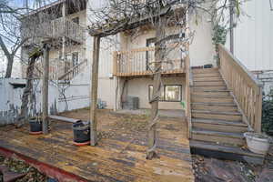 Back of property featuring a balcony and cooling unit