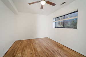 Empty room with wood-type flooring and ceiling fan