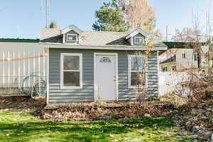 View of front of house with a front yard and an outbuilding