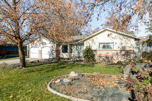 Ranch-style house with a front yard and a garage