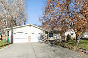 View of front facade featuring a front yard and a garage