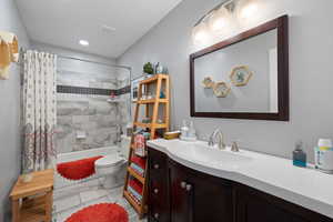 Full bathroom featuring vanity, toilet, and tiled shower / bathtub combination with curtain