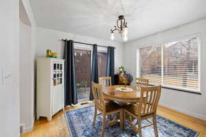 Dining area with a chandelier and light hardwood flooring