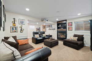 Carpeted living room featuring a large fireplace and projector