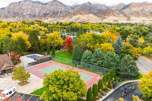 Bird's eye view of tennis court, pool, clubhouse, and mountains