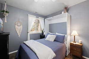 Guest Bedroom featuring ceiling fan and dark wood-style floors and murphy bed