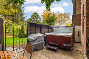 View of back patio with a grill and a hot tub