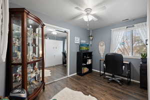 Guest Bedroom featuring ceiling fan, dark wood-style floors, a desk and a closet