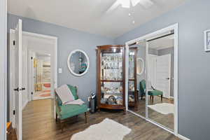 Guest Bedroom featuring ceiling fan, dark wood-style floors, and a closet