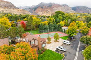 Bird's eye view of tennis court, clubhouse, and mountains