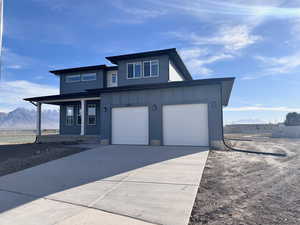 View of front of home featuring covered porch, a mountain view, and a garage