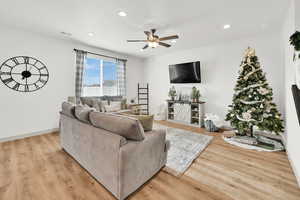 Living room with ceiling fan and light hardwood / wood-style flooring