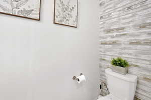 Bathroom featuring toilet and wooden walls