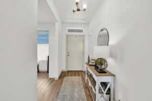 Entrance foyer with light hardwood / wood-style flooring and a notable chandelier