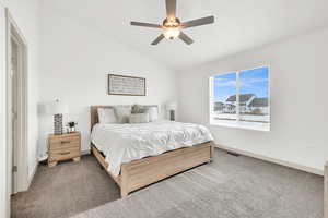 Bedroom with carpet, ceiling fan, and lofted ceiling