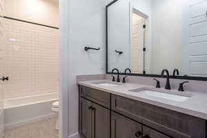 Full bathroom featuring vanity, toilet, and tiled shower / bath