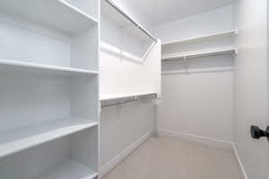 Spacious closet with light colored carpet