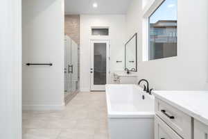 Bathroom featuring plus walk in shower and vanity