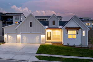 View of front of property with a garage and a lawn