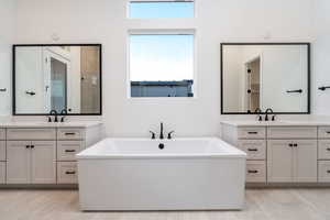 Bathroom with plenty of natural light, a tub, and vanity