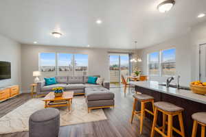 Living room featuring an inviting chandelier, light wood-type flooring, and sink