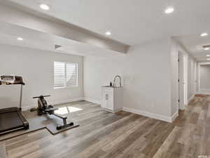 Exercise area featuring sink, a textured ceiling, and light wood-type flooring