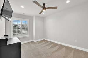 Unfurnished room with light colored carpet and ceiling fan