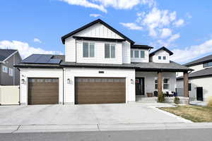 Modern farmhouse style home featuring solar panels and a garage