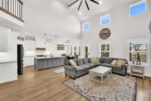 Living room featuring light hardwood / wood-style floors, a high ceiling, and a chandelier