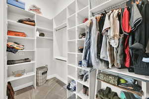 Walk in closet with light colored carpet