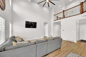 Living room featuring hardwood / wood-style floors, plenty of natural light, and a high ceiling