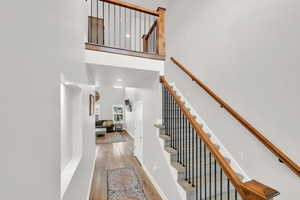 Stairs with wood-type flooring and a high ceiling