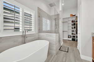 Bathroom featuring plus walk in shower and hardwood / wood-style flooring