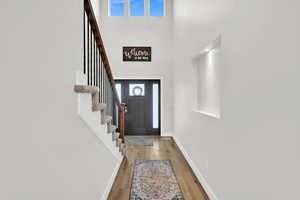 Foyer entrance with a towering ceiling and hardwood / wood-style flooring