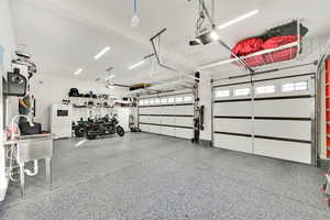 Garage with white refrigerator and a garage door opener