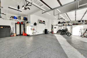 Garage with a garage door opener and white refrigerator