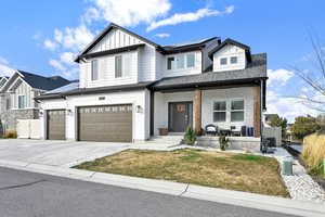 View of front facade with a front yard, solar panels, a garage, and cooling unit