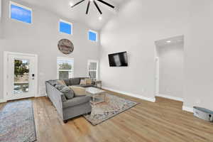 Living room featuring high vaulted ceiling and light hardwood / wood-style floors