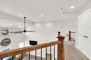 Corridor with light carpet and vaulted ceiling