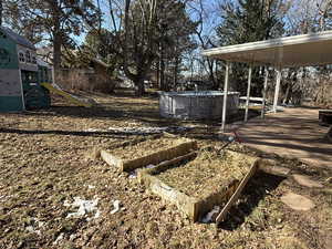 View of yard featuring a playground, a garden, and an outdoor pool