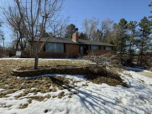 View of front facade with a chimney and brick siding