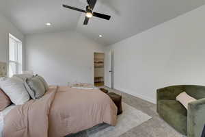 Primary Bedroom featuring ceiling fan, light colored carpet, and vaulted ceiling