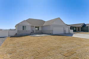 View of front of home with a garage, a shingled roof, fence, concrete driveway, and board and batten siding