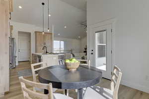 Dining space with light hardwood / wood-style floors and sink