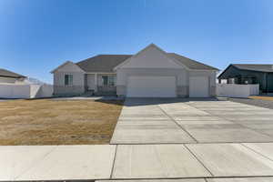View of front of home with board and batten siding, fence, driveway, and an attached garage
