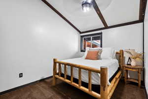 Bedroom with ceiling fan, dark carpet, and lofted ceiling