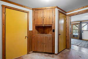 Hall with a textured ceiling and wooden walls