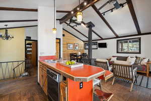 Kitchen with dark hardwood / wood-style flooring, dishwasher, lofted ceiling with beams, and sink