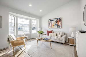 Living room with light hardwood / wood-style flooring and lofted ceiling